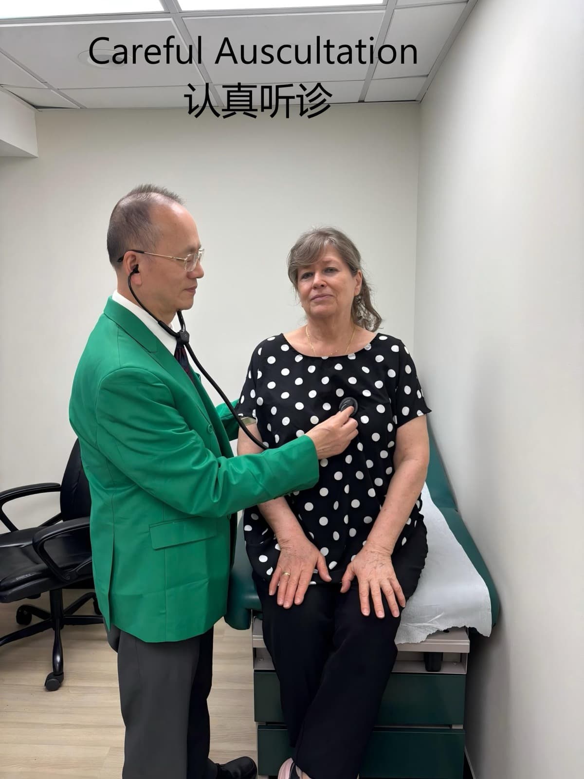 李健医生身着绿西装，认真为坐姿年长女患者听诊