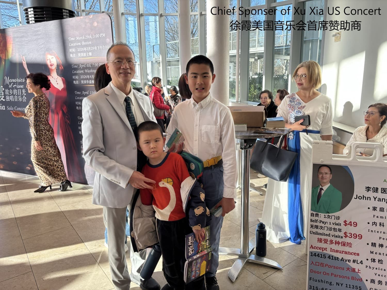 Dr. Lee with family and audience at a concert venue; a standing poster on the right lists clinic services