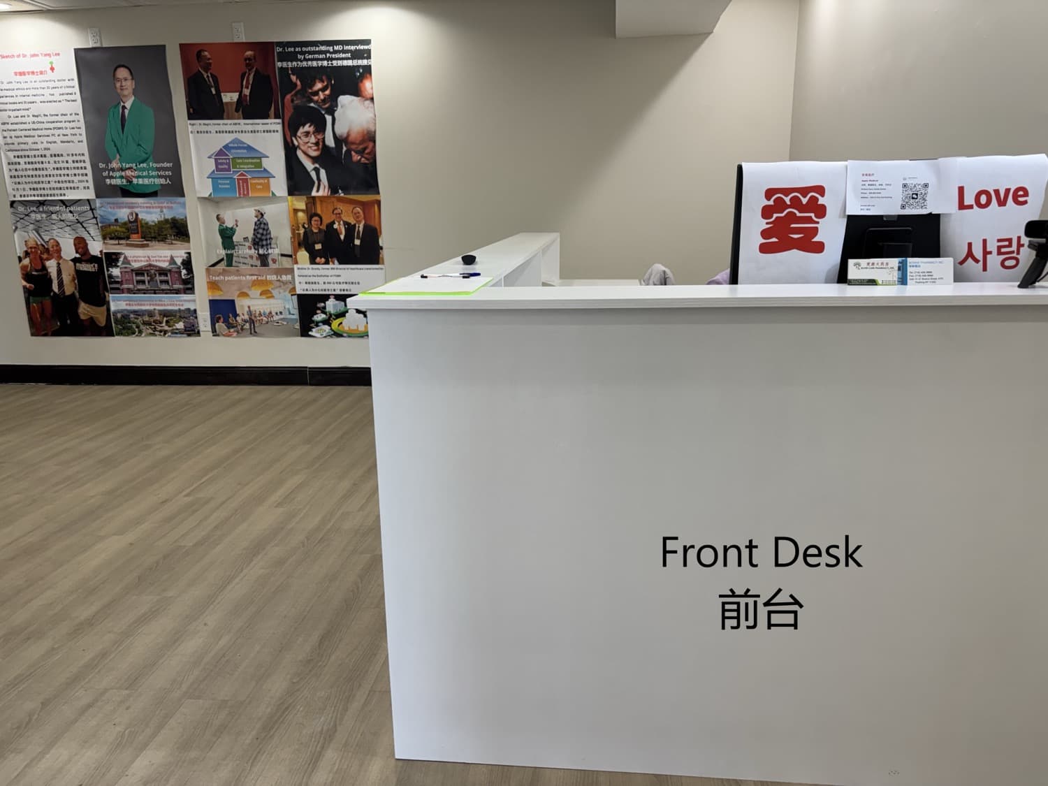 Clinic front desk with a wall display reading Love in three languages and a poster wall introducing the physician