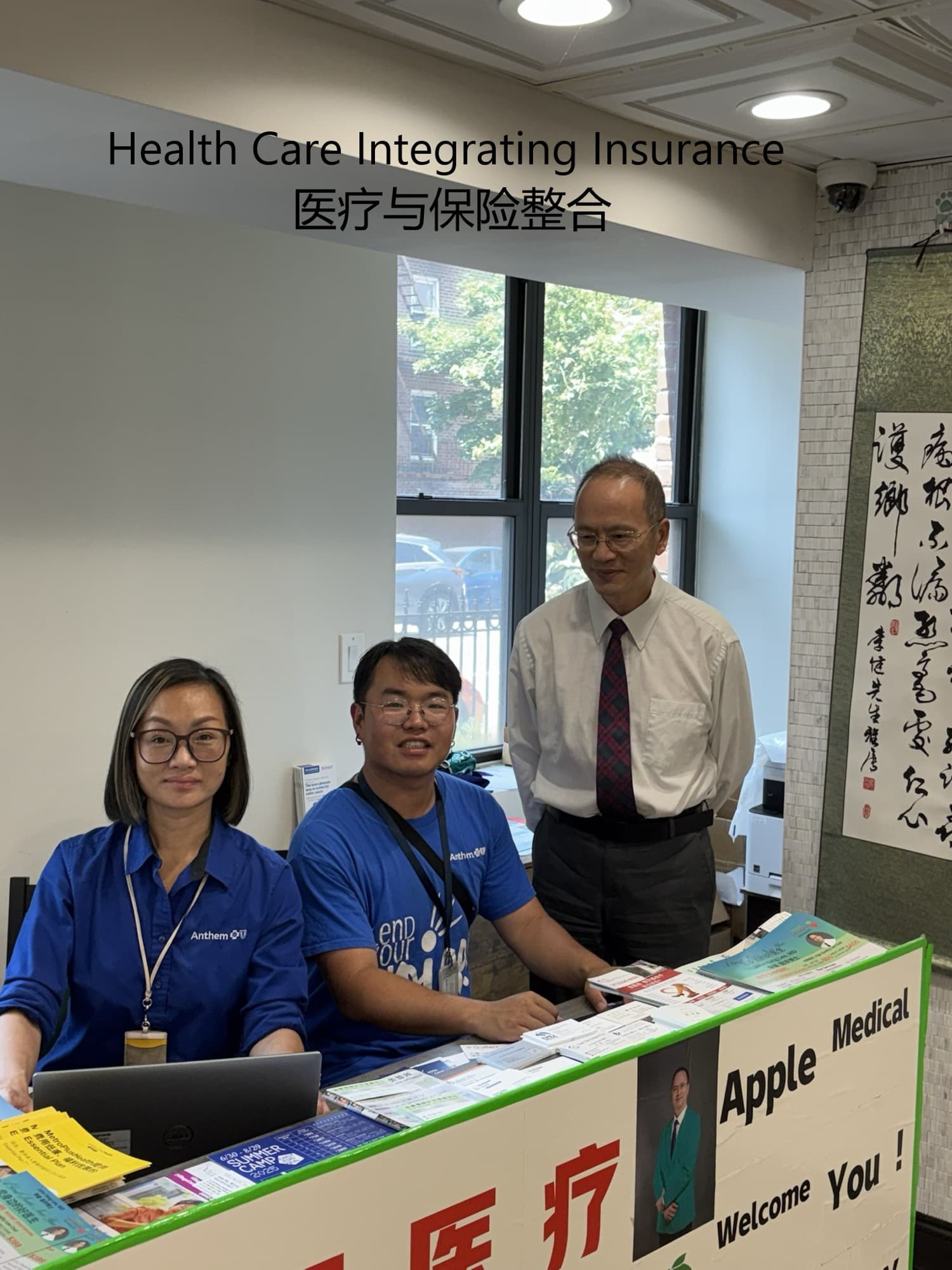 Two Anthem insurance representatives seated at the clinic front desk with Dr. Lee