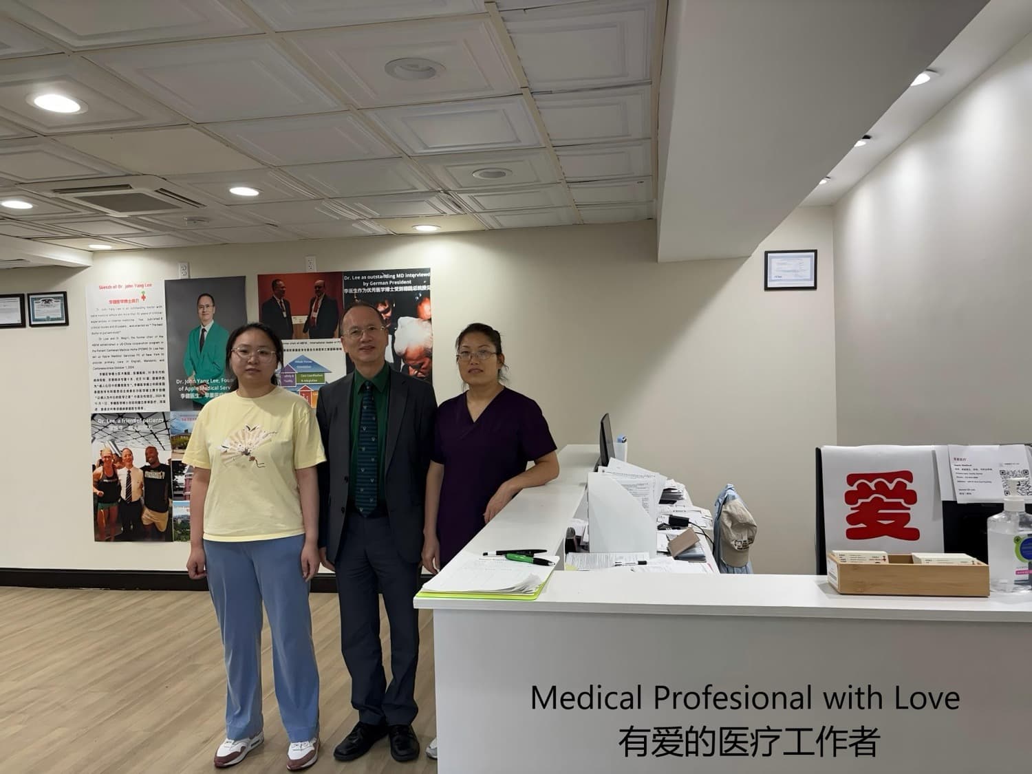 Dr. Lee with two staff members at the front desk beside the Love display