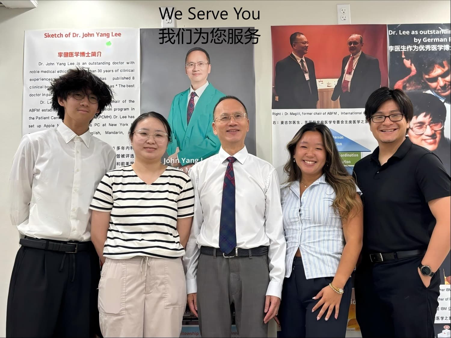 Dr. Lee and four staff members posing together indoors in front of a wall of posters
