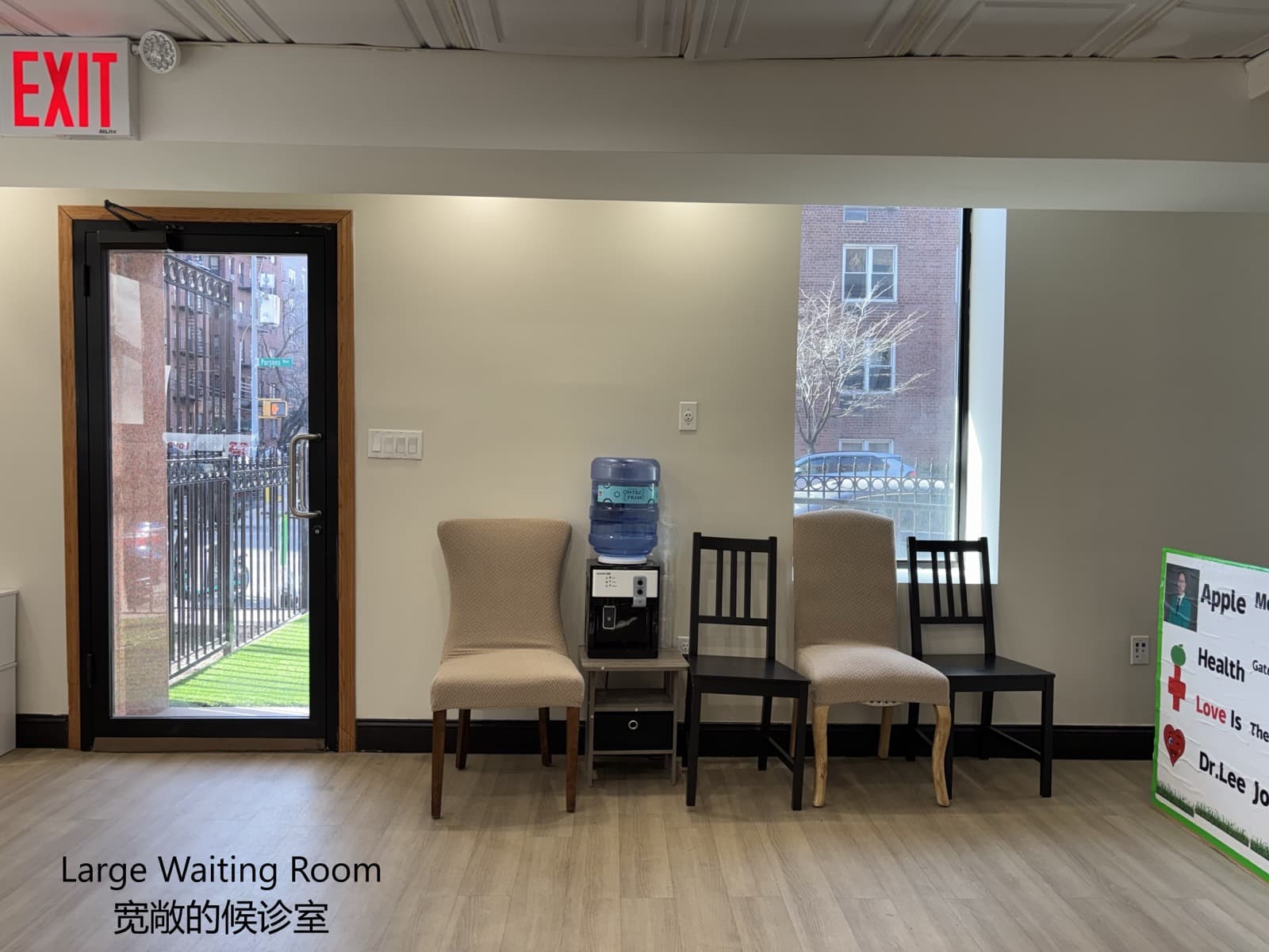 A spacious clinic waiting room with a water dispenser and a street-facing window