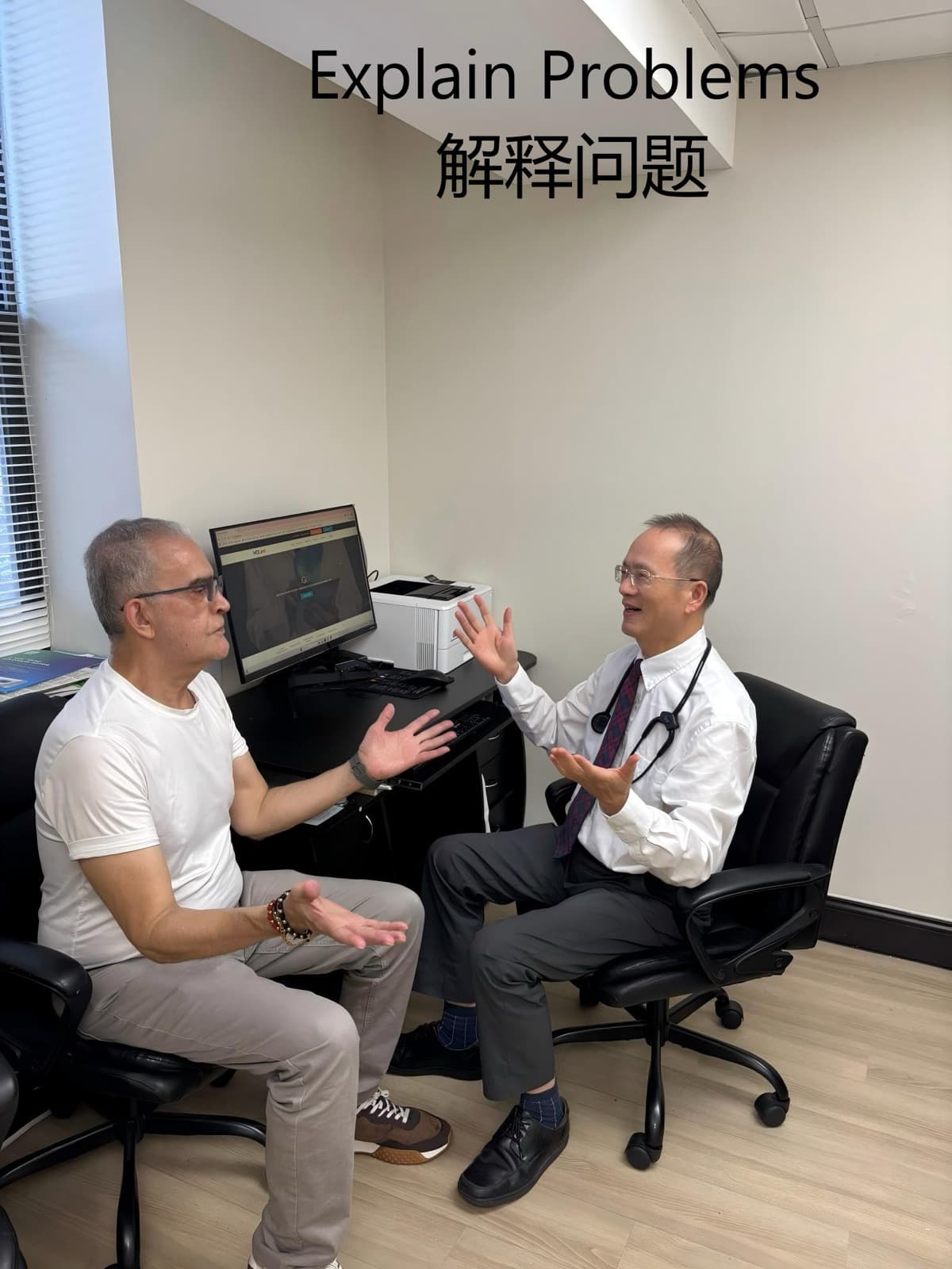 Dr. Lee in a white shirt sitting across from a patient, hands open while explaining